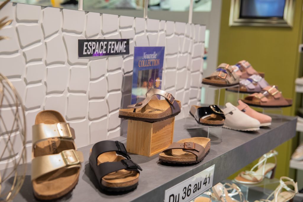 Etagères de chaussures dans la boutique Scott Premium où l'on voit des sandales ouvertes et fermées