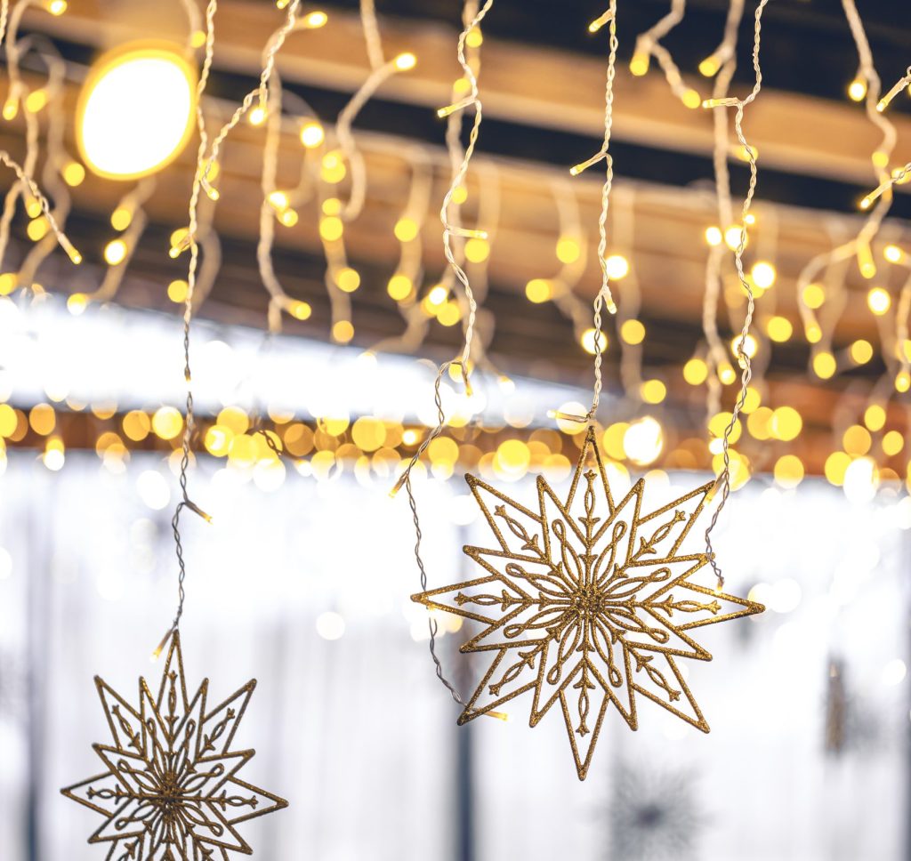 Decorative Snowflakes And Garlands On A Blurred Interior Background.